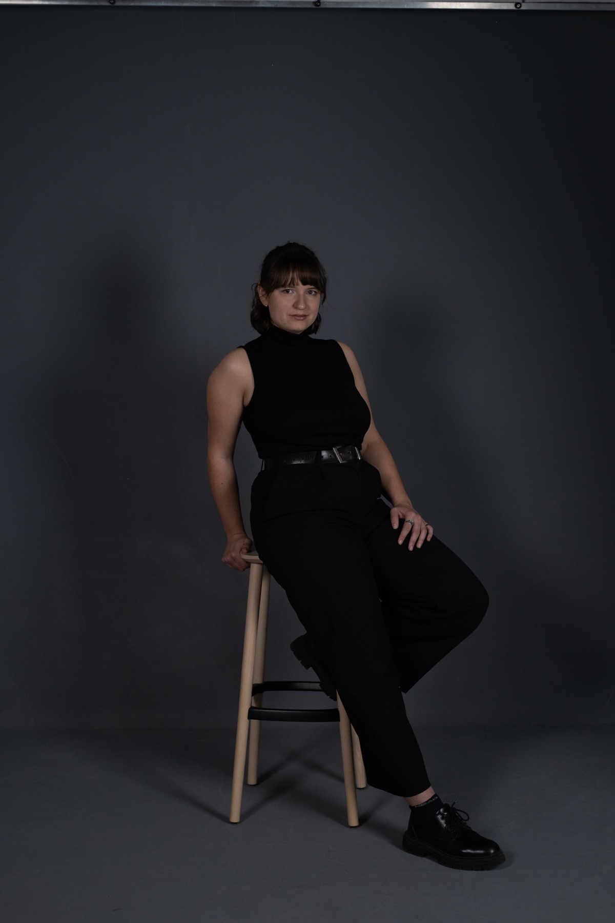 Portrait of Lenja Kausch sitting on a wooden stool